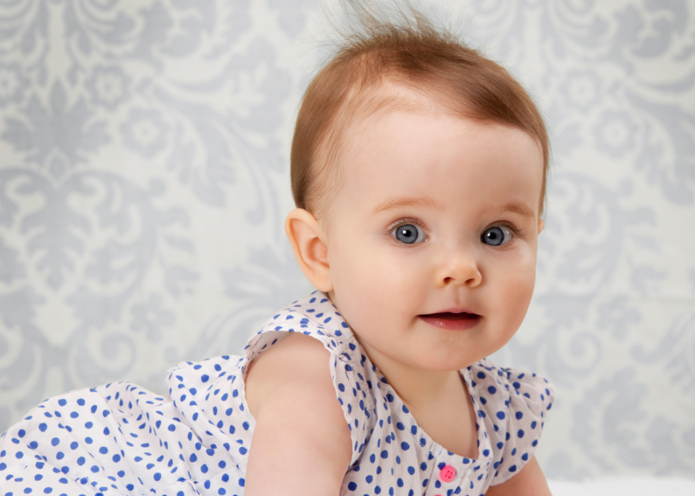 A red haired baby girl in a dress. 