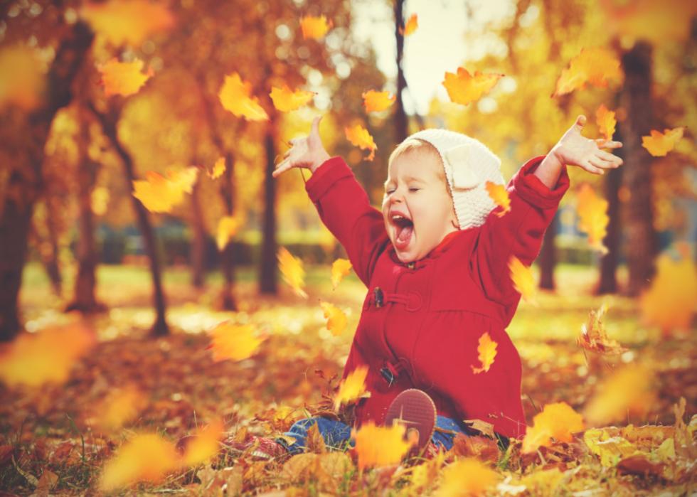 A baby girl laughing and playing outdoors.