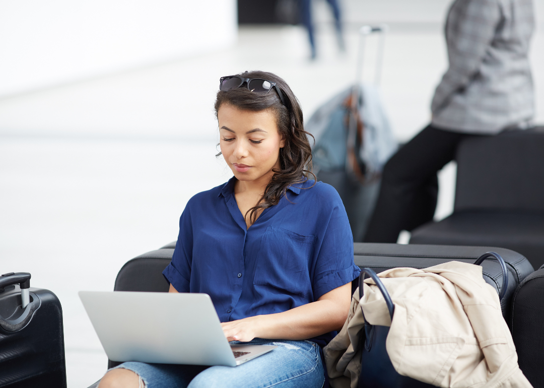 A woman using a laptop at an airport.
