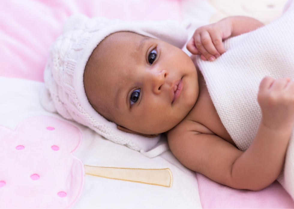 African baby girl lying under a blanket.