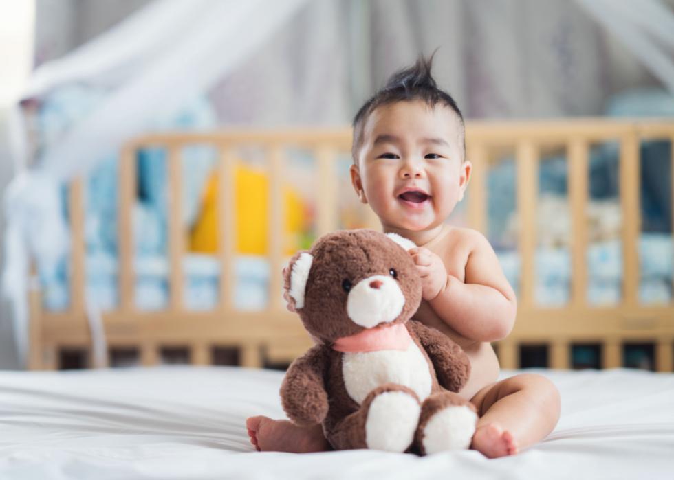 Asian baby boy holding a teddy bear.