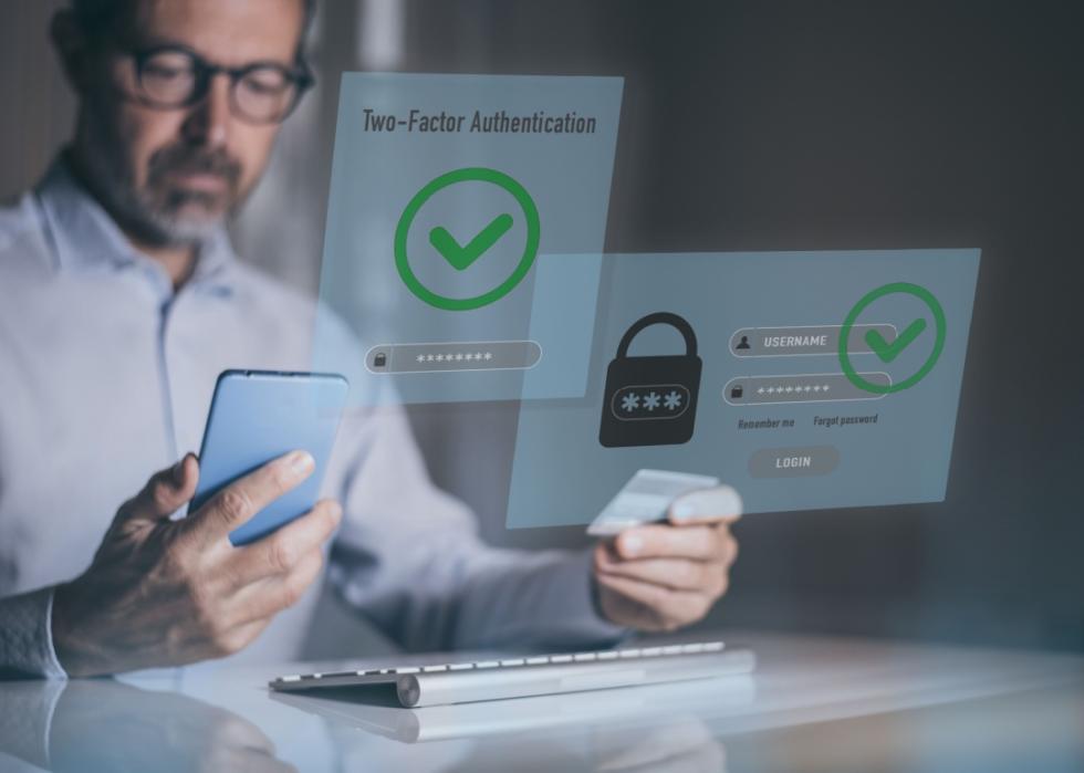 A man is looking at cell phone in the background. A login page for a website or application that requires two-factor authentication in the foreground.
