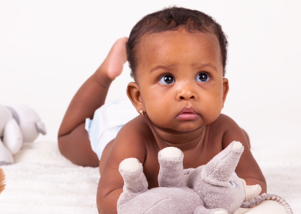 African American baby girl lying on her stomach.