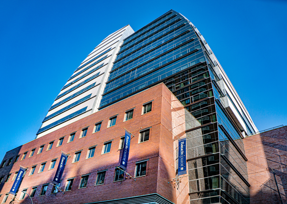 A modern glass and brick building with signs for Baruch College.
