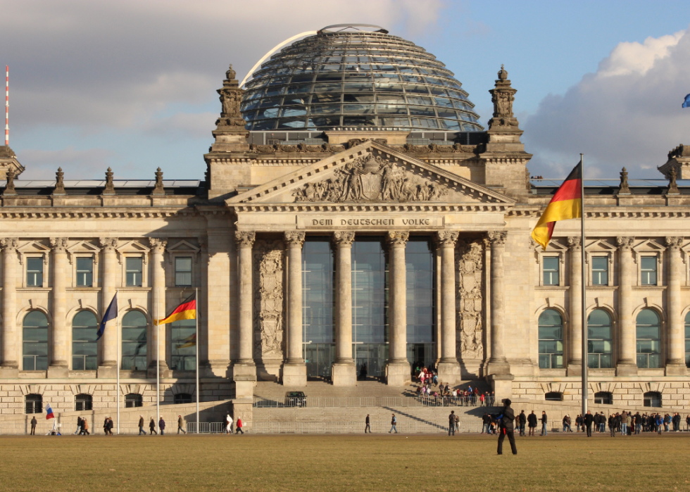 A parliament building with a glass dome on top and columns. 