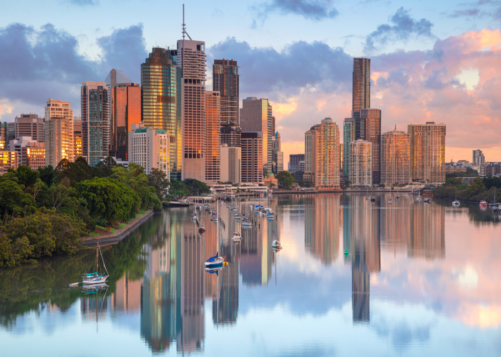 Talll, glass skyscrapers reflected in a body of water.