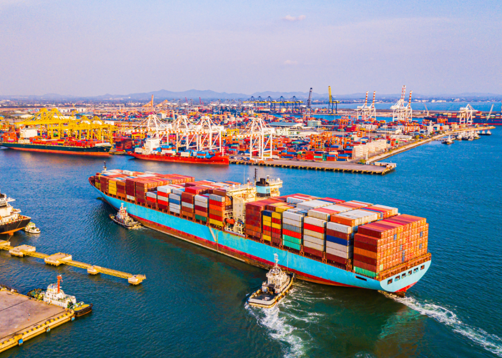 An aerial view of a large vessel with cargo containers., with many more like it in the background.