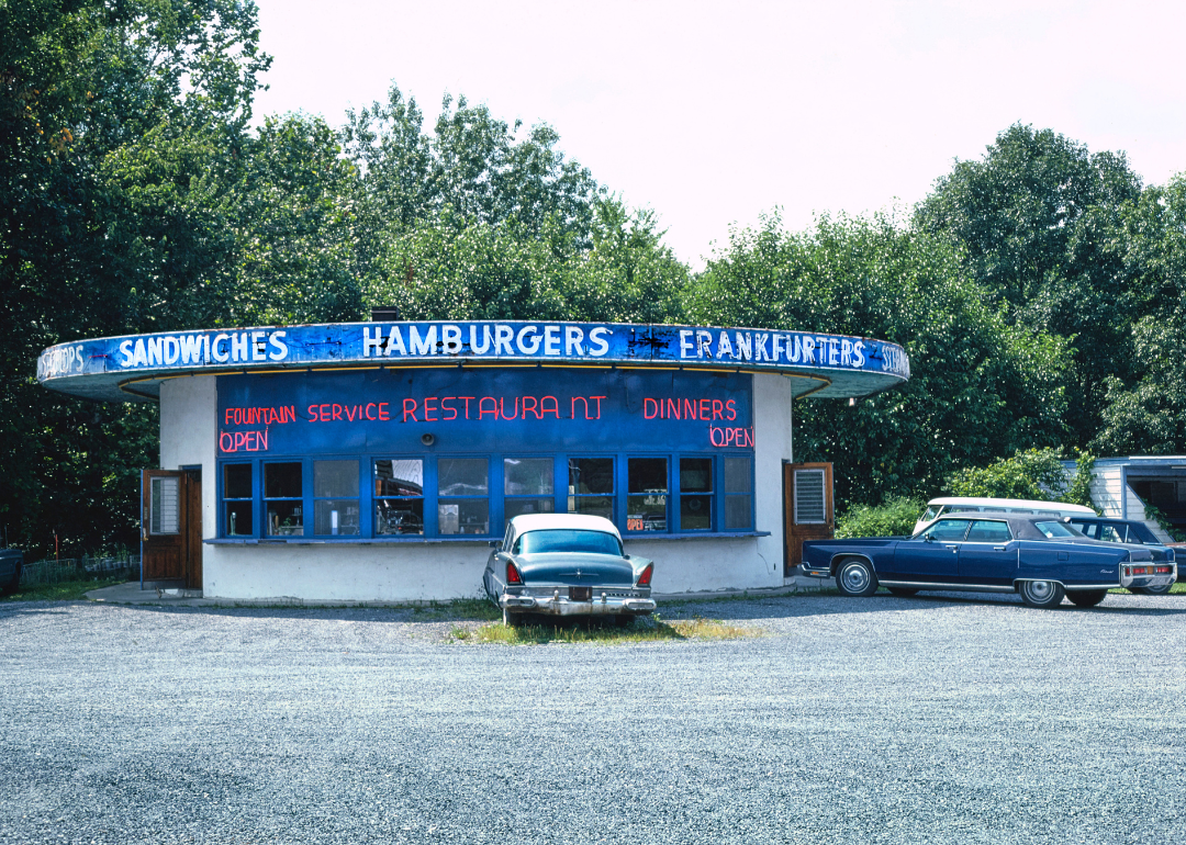A drive-in restaurant with cars parked outside in 1976.