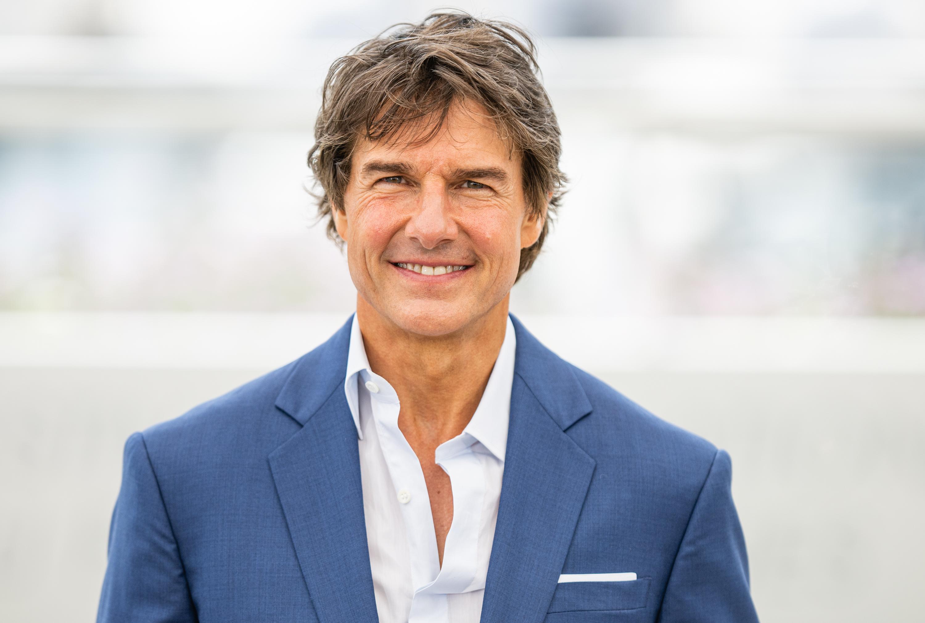 Tom Cruise in a blue suit jacket and white shirt.