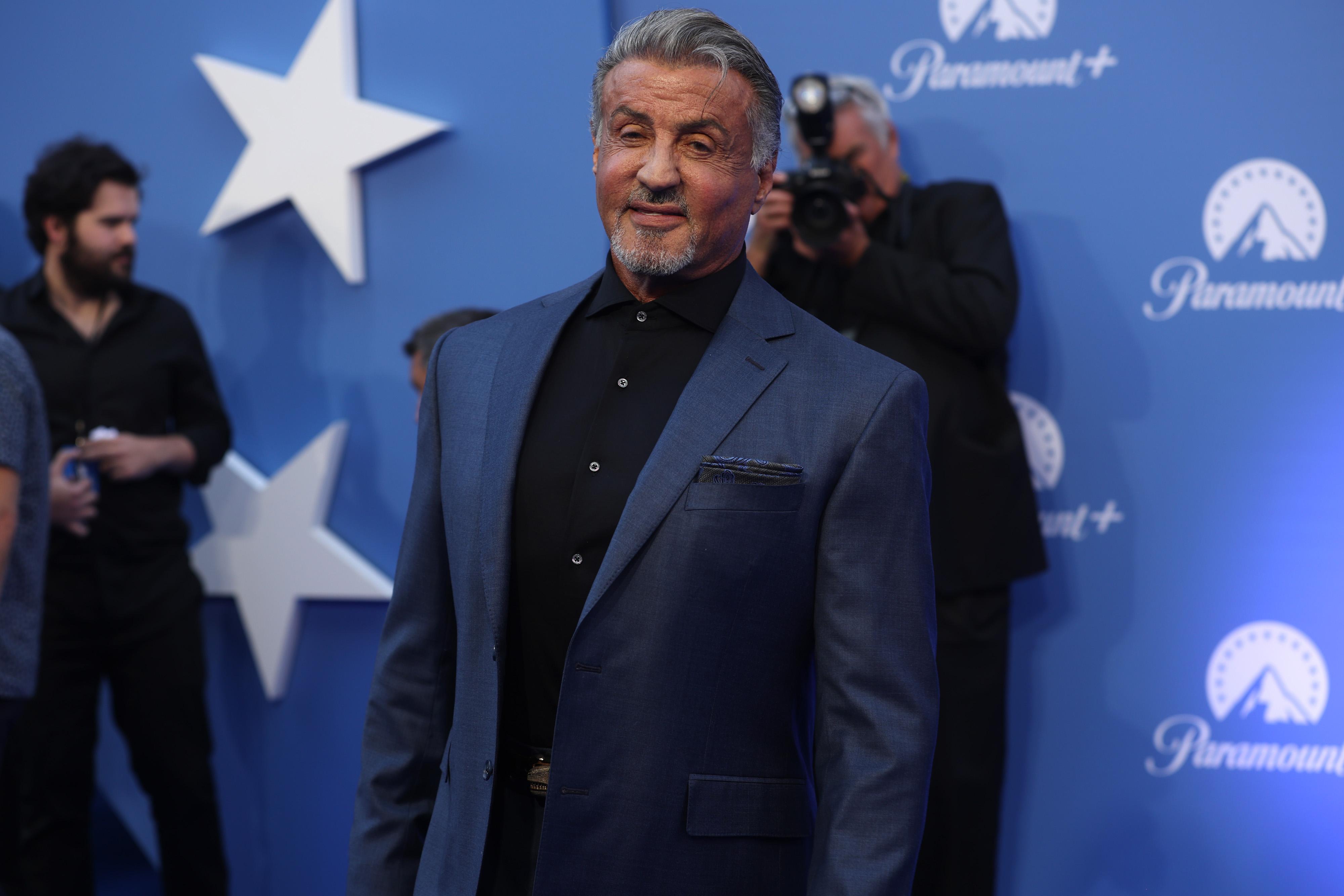 Sylvester Stallone in a dark blue suit.