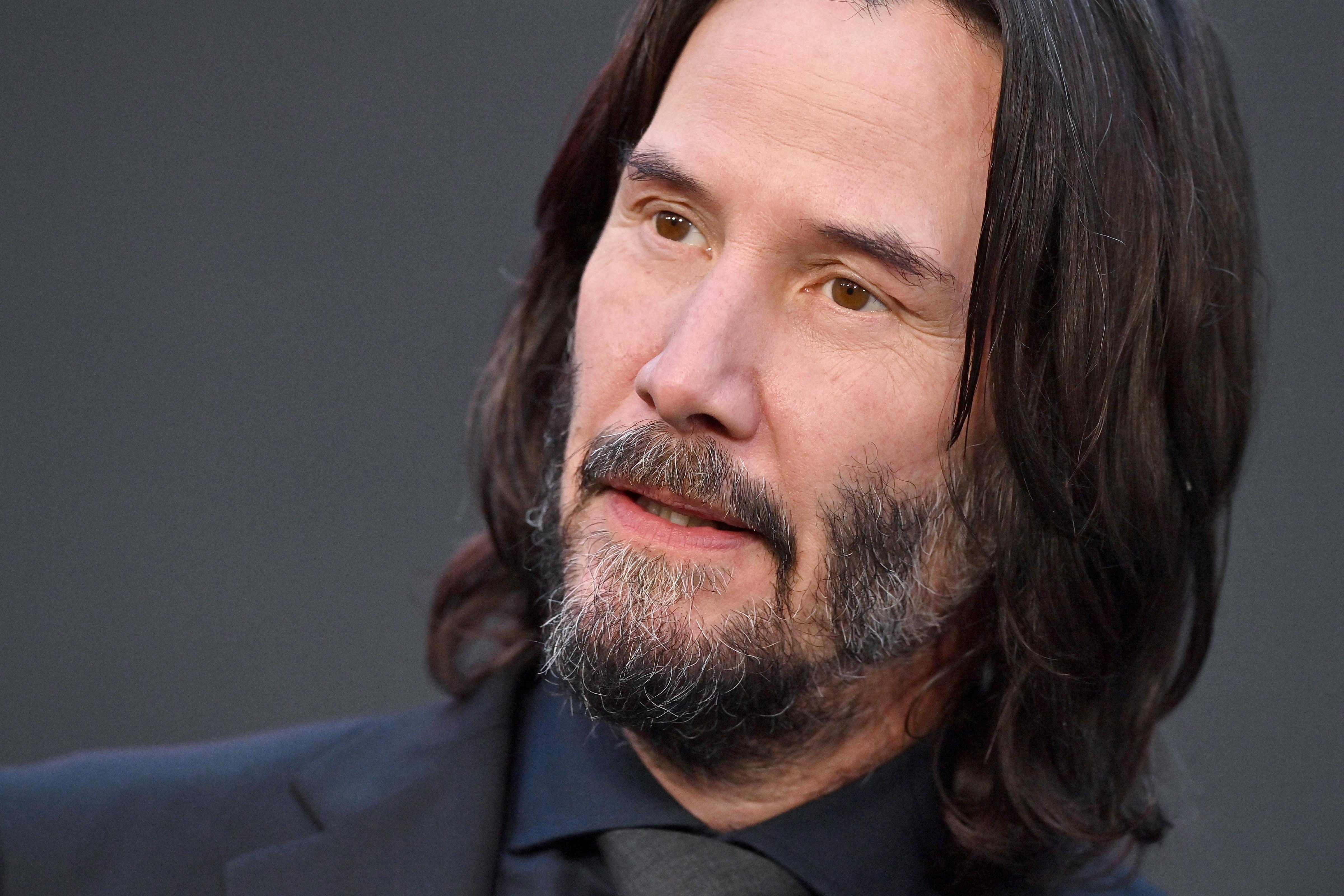 Keanu Reeves in a black suit.