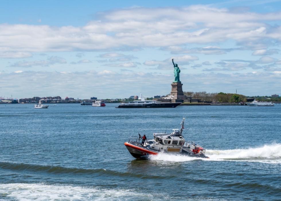 A U.S. Coastguard boat in front of the Statue of Liberty.