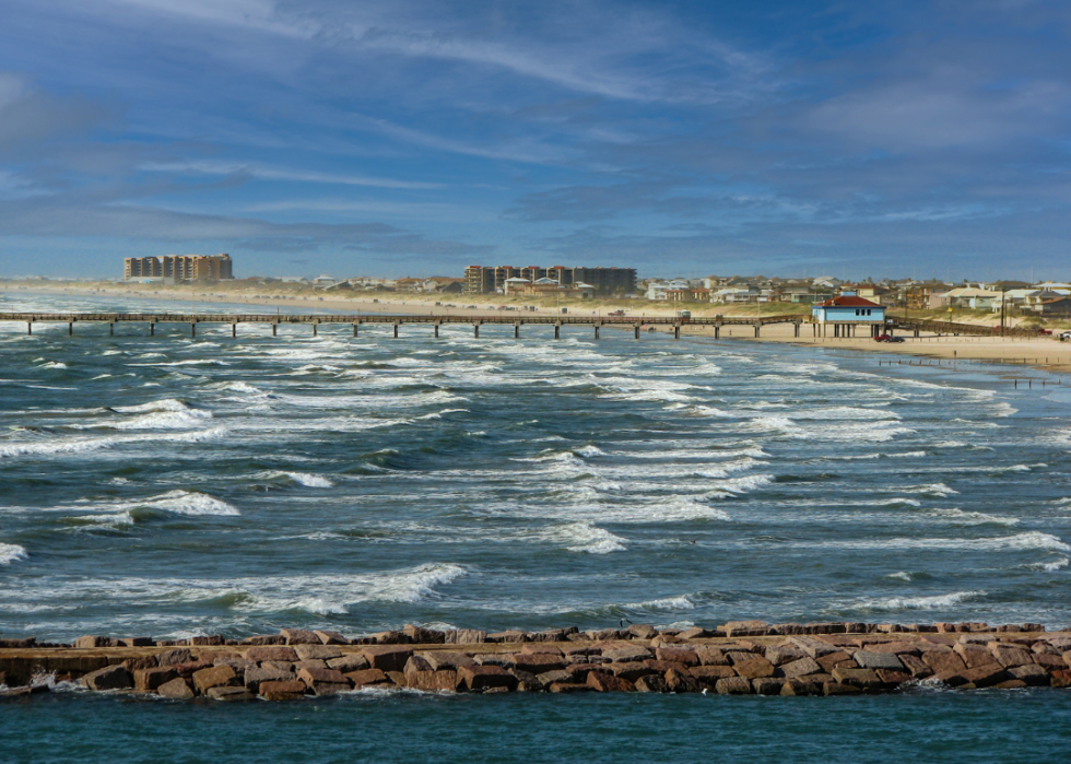 A beach with a pier in the background.