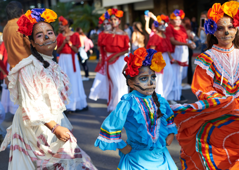 Three participants dressed as Catrinas, a character of Mexican popular culture, during the Day of the Dead parade celebrated in Mexico.