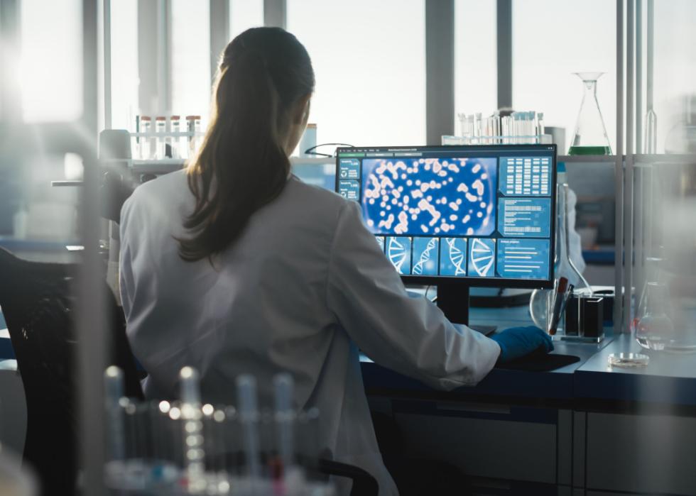 Female biochemist working on a computer.