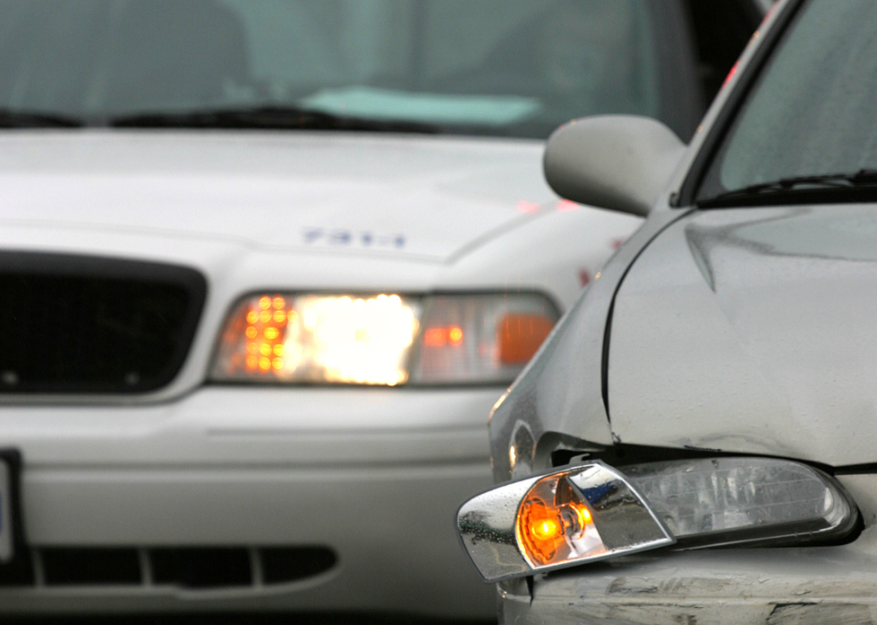 A police car pulling up to a minor car crash.