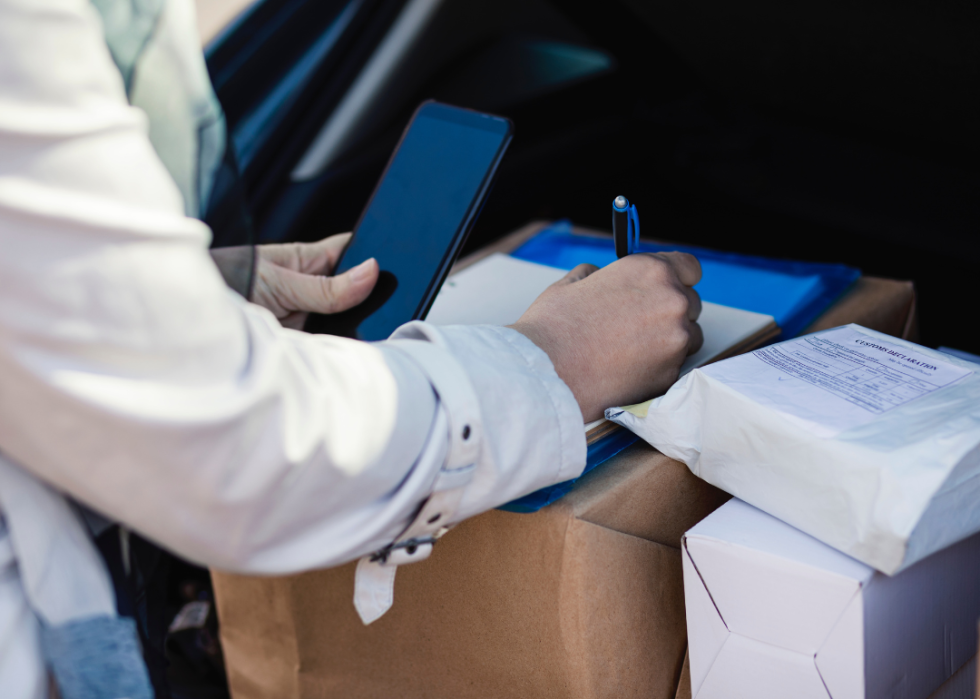 A person making deliveries from the back of a car.