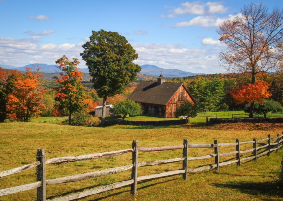 A historic building and wooden fence surrounded by Fall foliage.