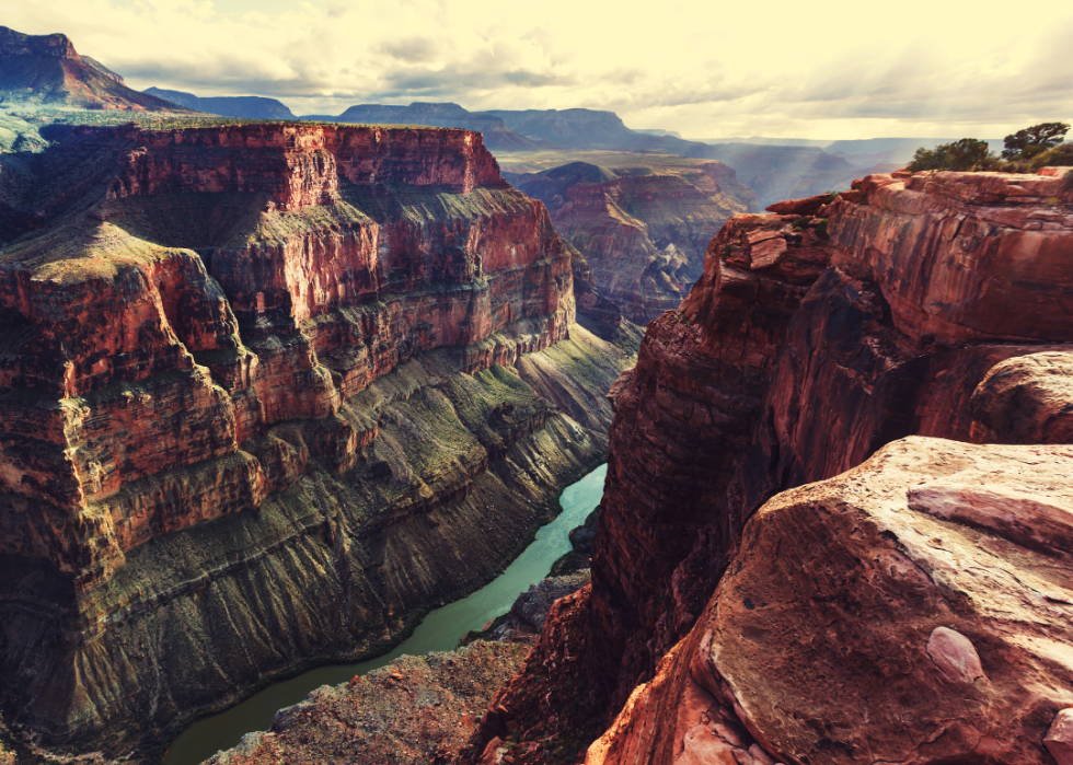 A red walled canyon with a winding turquoise river running through it.