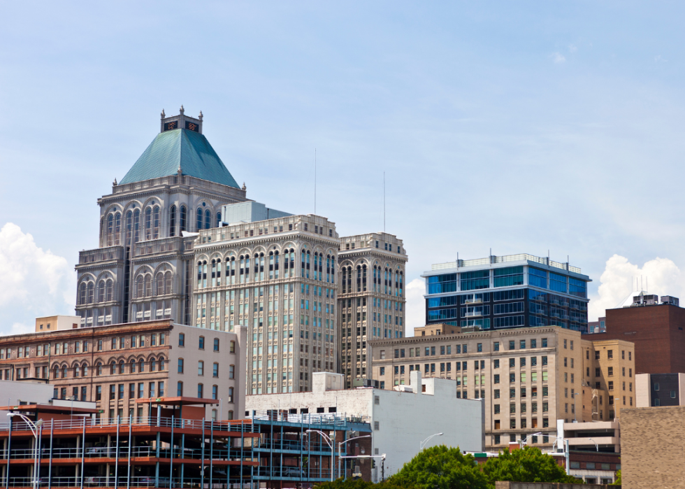 A city skyline with tall buildings and parking lots.