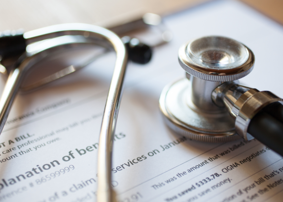 A stethoscope sitting on top of health insurance benefits document.