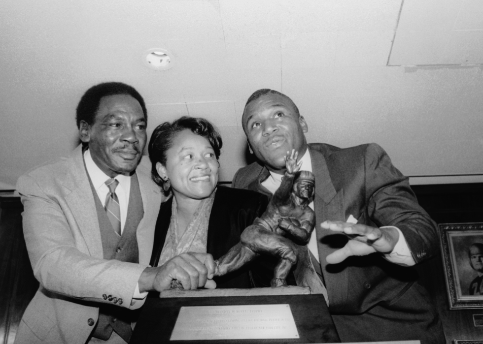 Heisman Trophy winner Barry Sanders and his parents stand by the trophy.