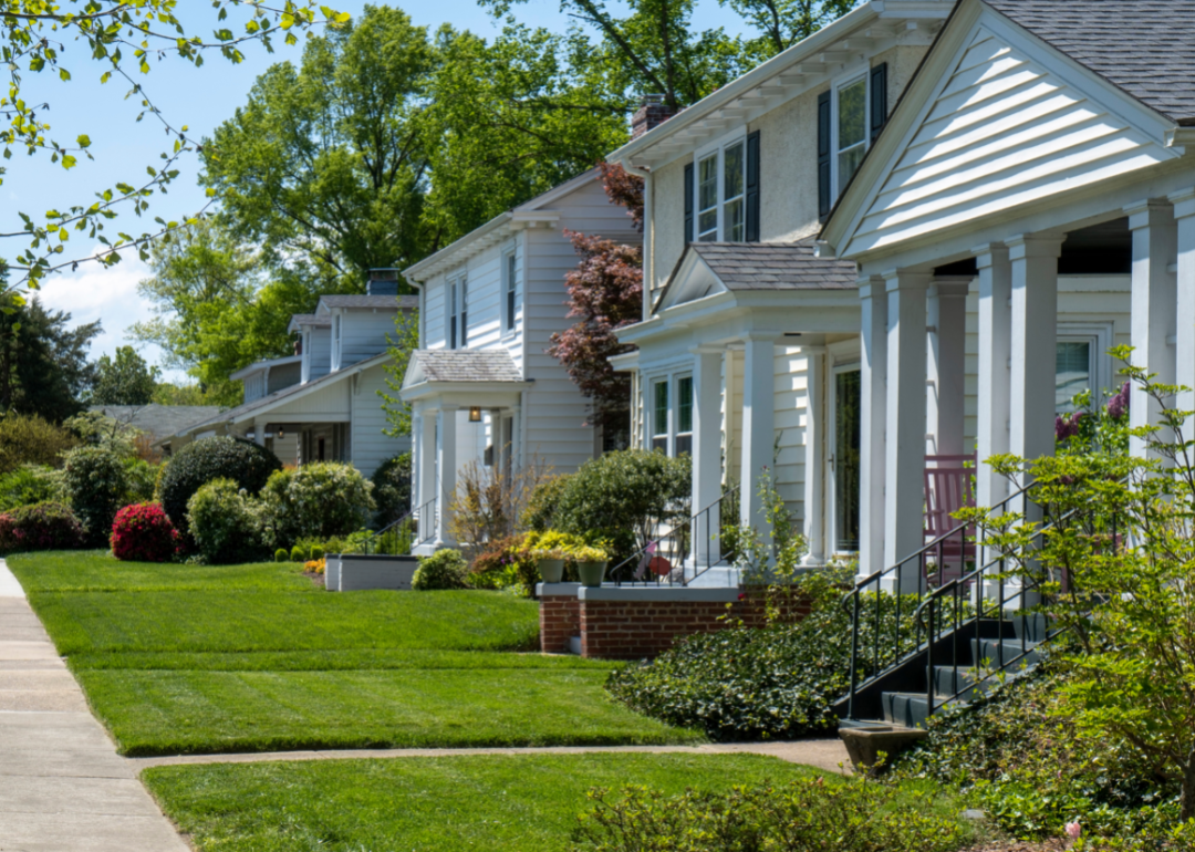A row of suburban homes with green front lawns.