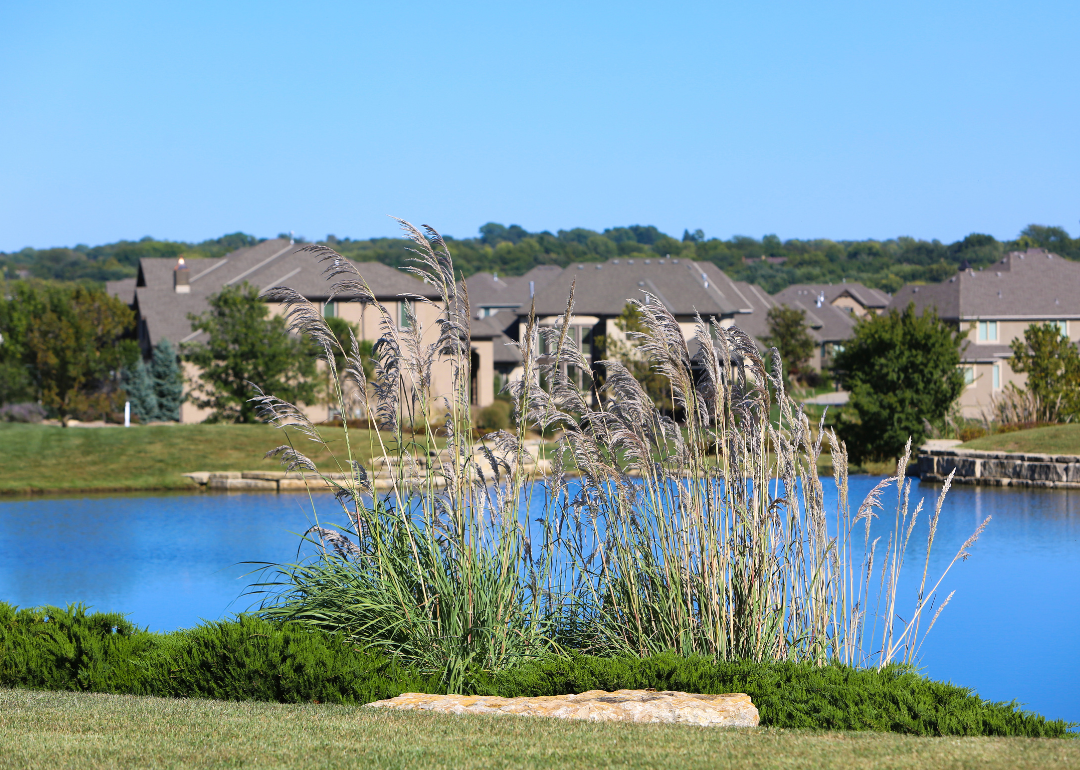 A small lake with large homes in the background.