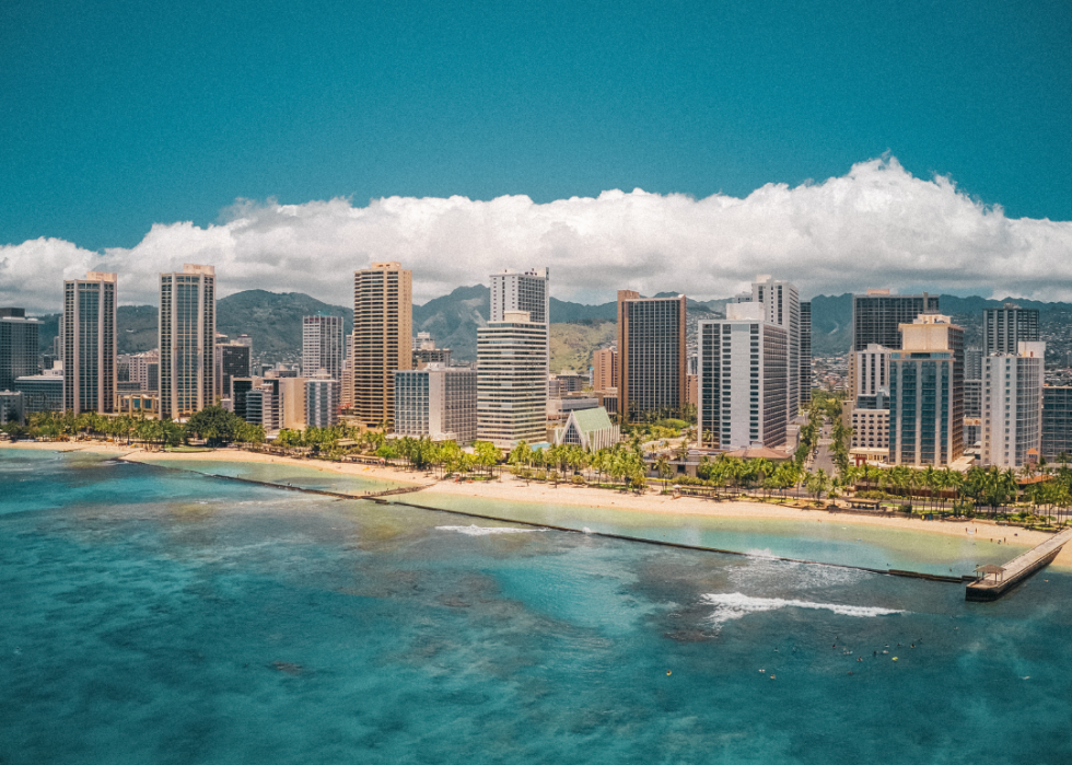 A city skyline dominated by tall buildings, beaches, and water.
