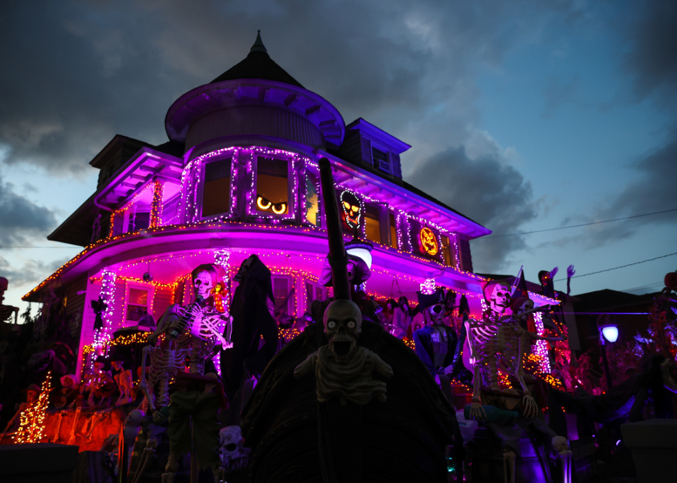 Halloween decorations placed around the home with horrific scene of skeletons, ghouls, ghosts, and monsters wrapped around the house and onto the porch in a Whitestone of Queens in New York.