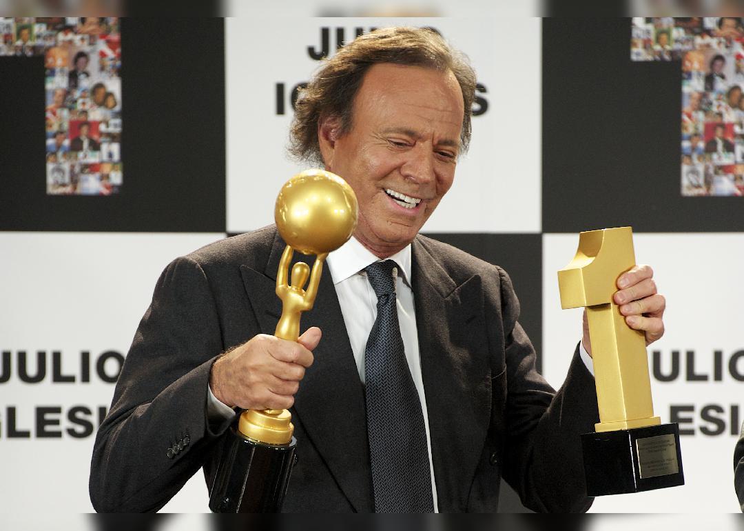 Julio Iglesias smiles with award.