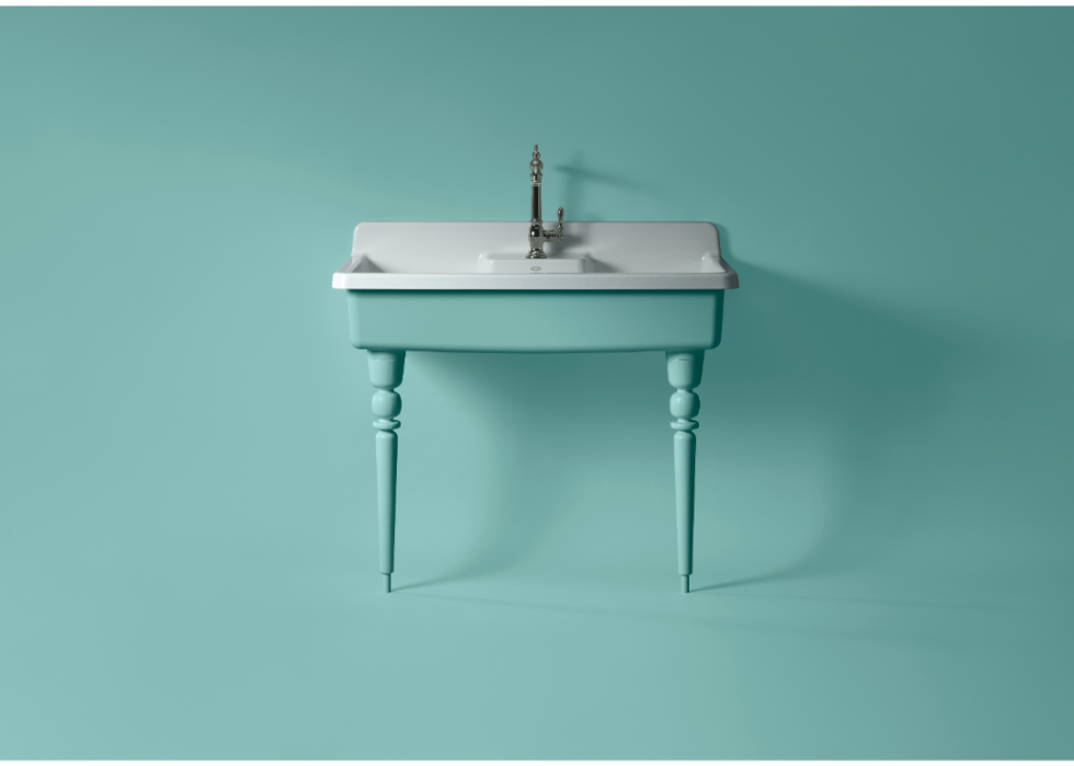 A freestanding Kohler sink in spring green against a backdrop of the same color.