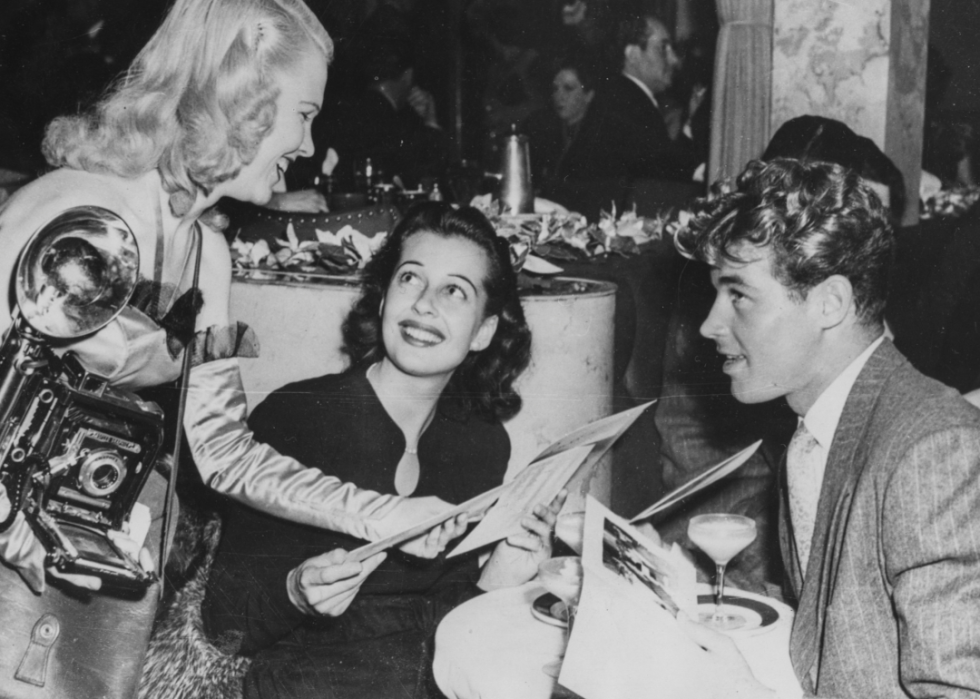 Famous patrons chat with a photographer in Ciro's
