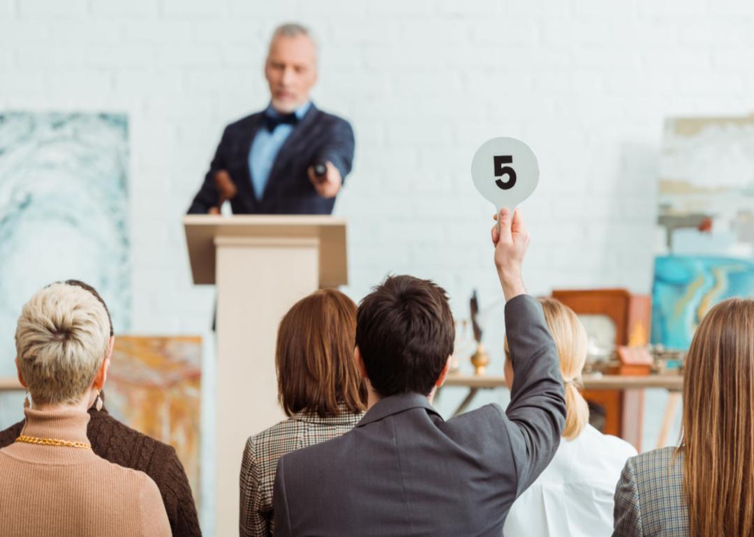 An auctioneer addressing the audience at an art auction