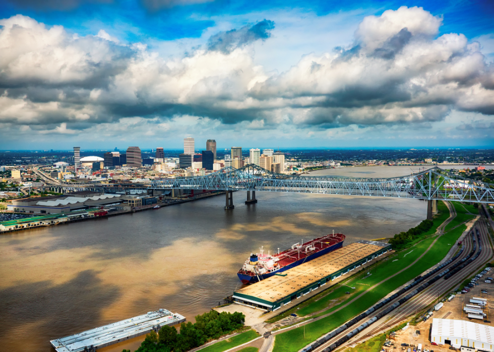 City skyline by the wide river and iron bridge in the foreground.