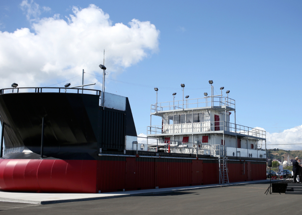 Black, red and white large vessel anchored in the port.