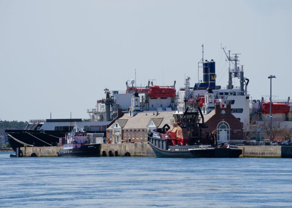 Buildings and ships anchored by the river.