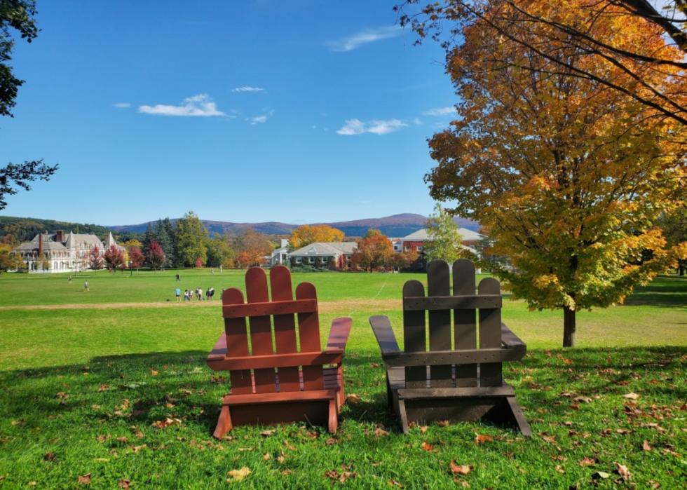 Two adirondack chairs overlooking Fall foliage at Middlebury College.