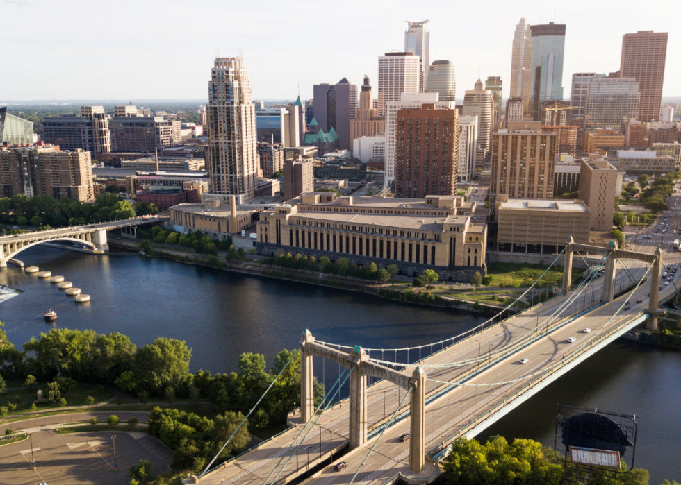 City skyline by the river with a bridge in the foreground.