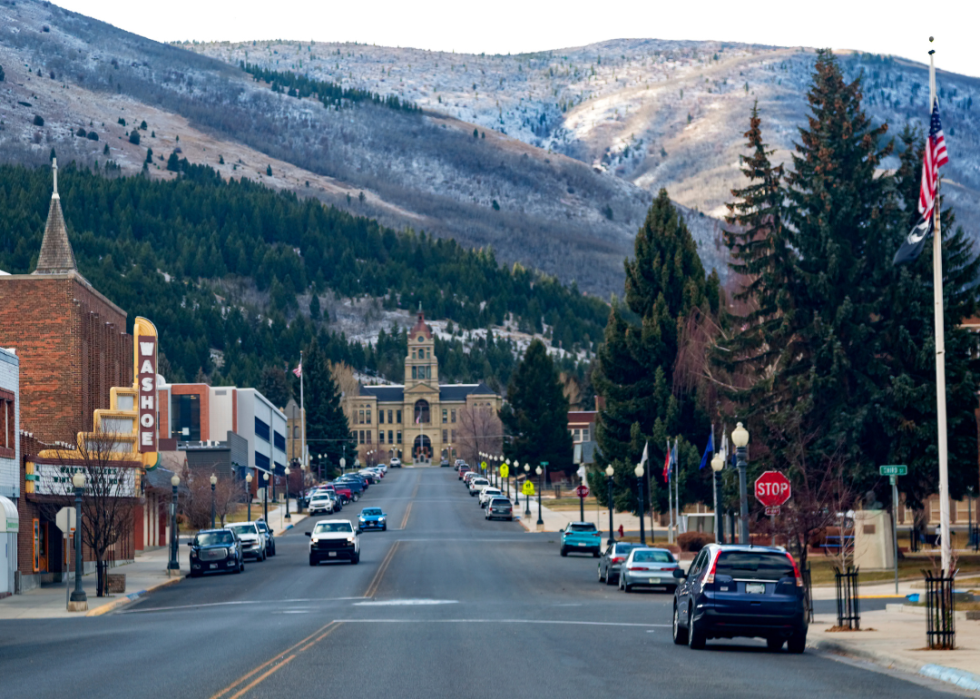 Downtown traffic in small town with mountains in the background.