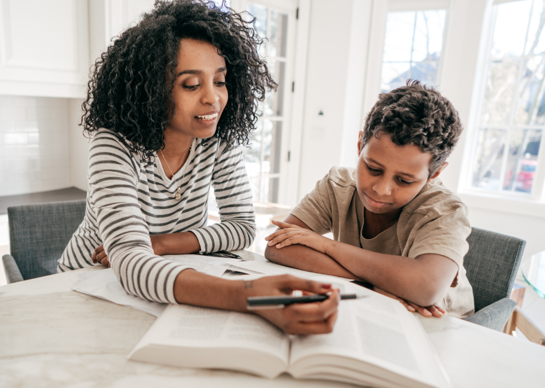 A woman works with a young child using books.