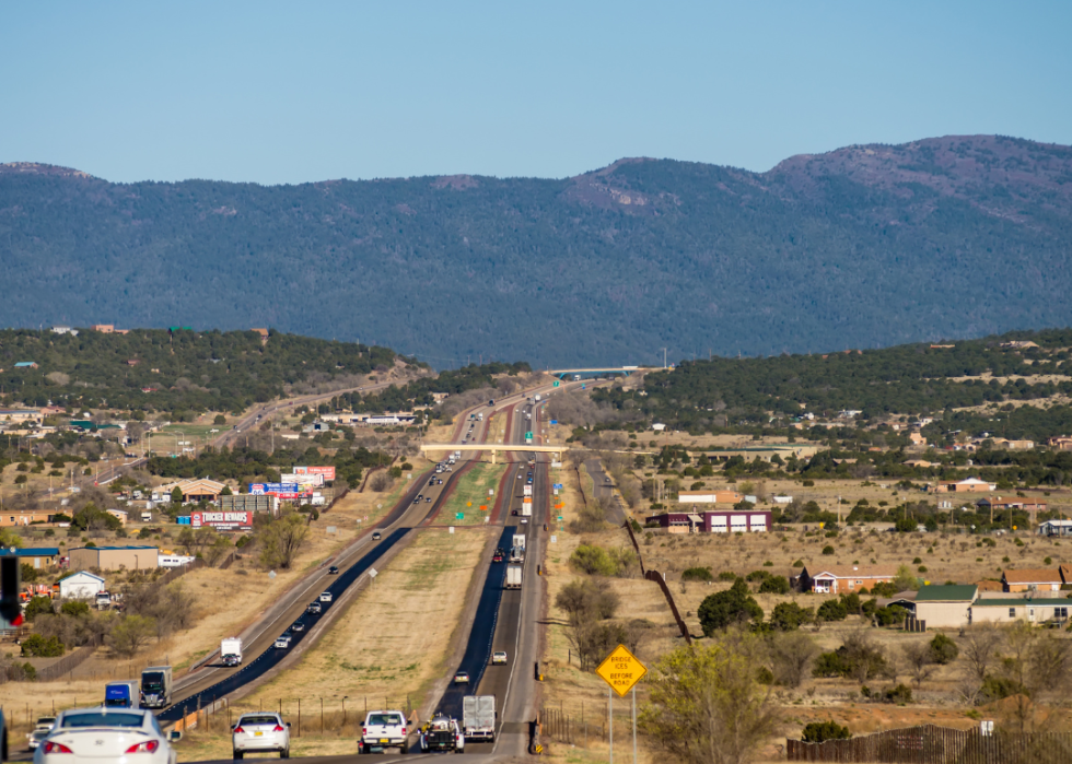 Long stretch of highway with mountains in the background.
