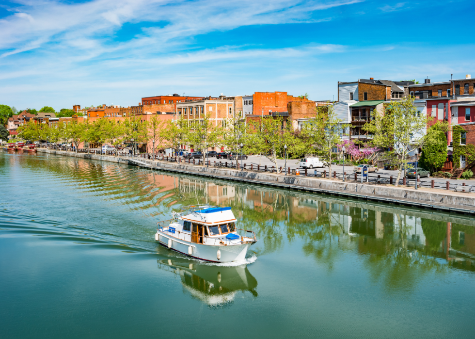 Row of brick buildings by the canal with a boat.
