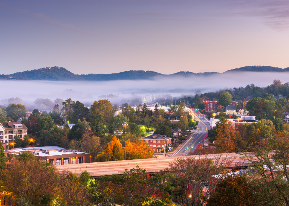 View of the city with lots of trees and foggy mountains in the background.