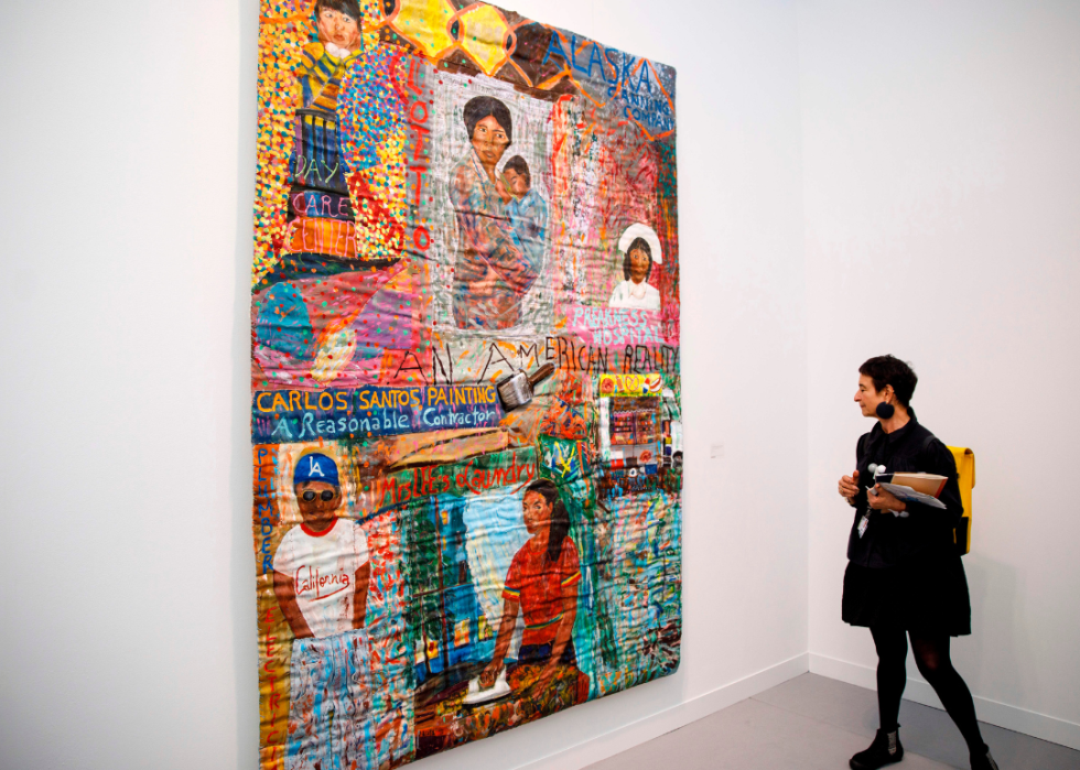 A woman views an artwork titled 'I thought the streets were paved with gold' by Pacita Abad at the Frieze Art Fair in London.