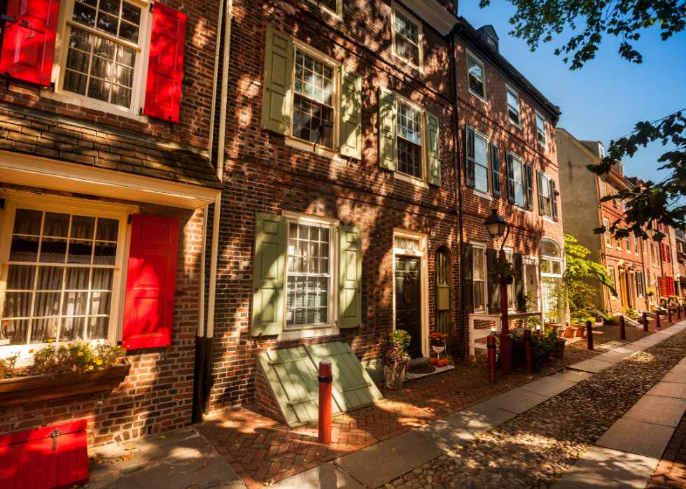 A row of brick buildings on a cobblestone street.