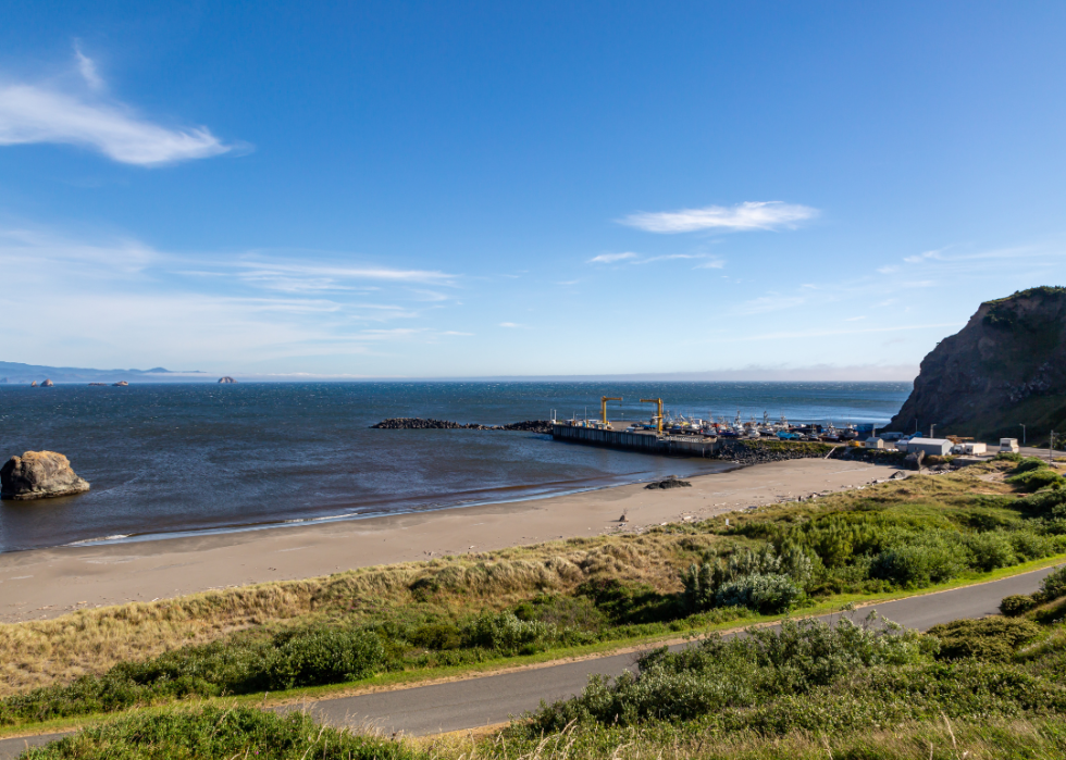 A beach with a pier in the background.