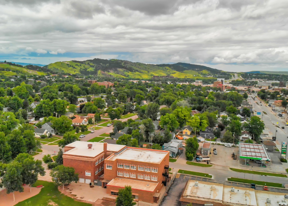 A city downtown surrounded by green hills. 