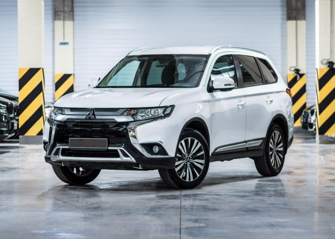 A white Mitsubishi Outlander in a warehouse.