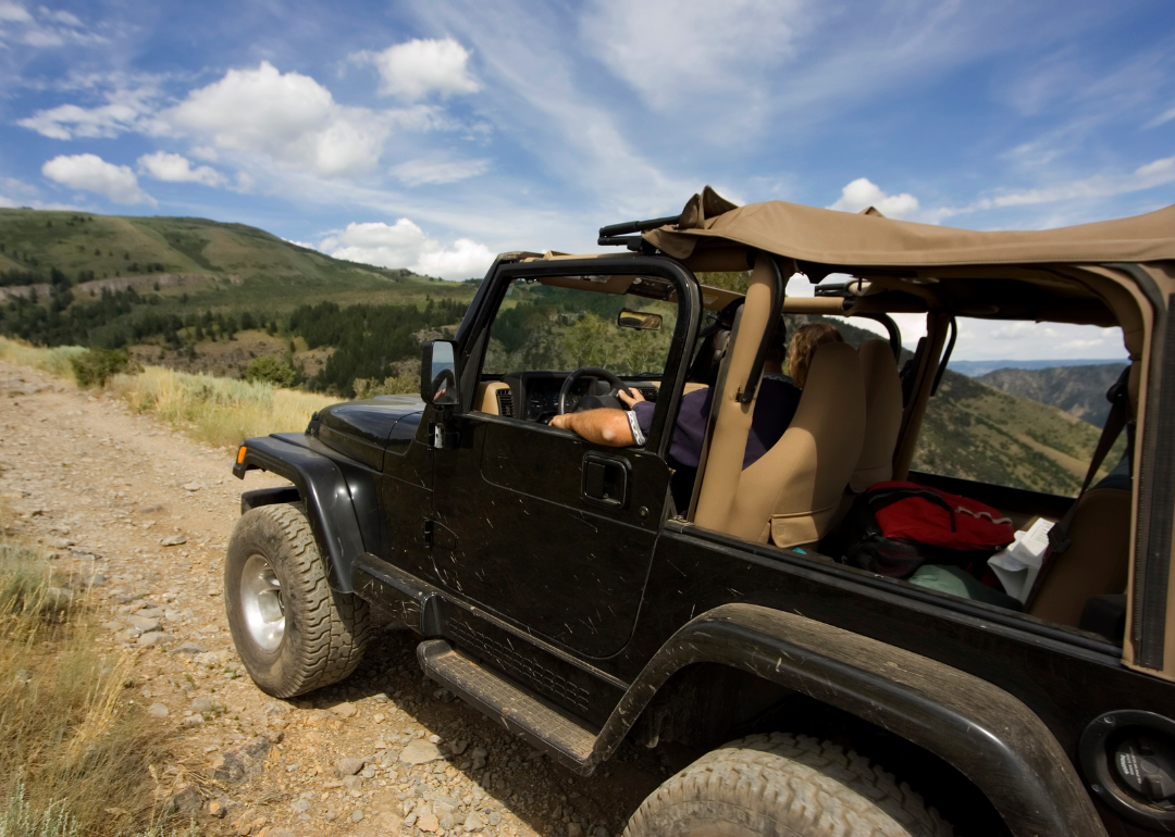 A Jeep Wrangler driving on a rugged road.
